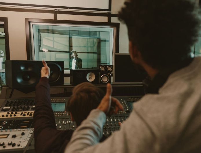 sound producers showing thumbs up to singer at recording studio